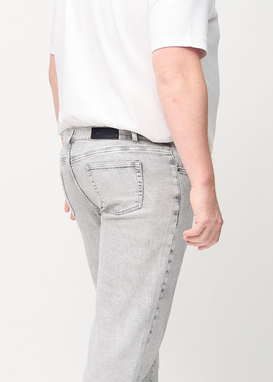 Ljusgrå denim regular jeans sedd bakifrån i närbild på en plus size-modell för att visa detaljer.