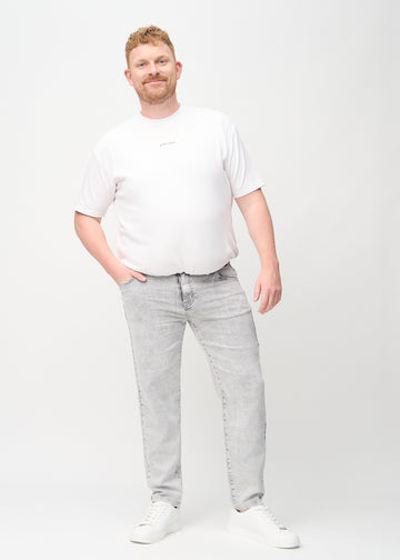 Helbild av en plus size-modell i ljusgrå denim regular jeans.