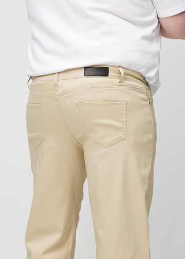 Närbild bakifrån av beige regular jeans på en plus size-modell som visar detaljer.