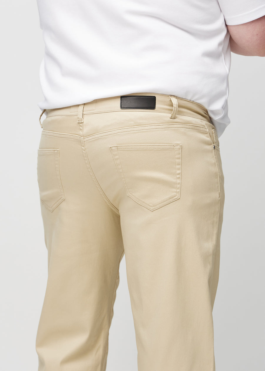 Närbild bakifrån av beige regular jeans på en plus size-modell som visar detaljer.