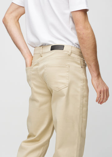 Närbild bakifrån av beige regular jeans som visar detaljer.