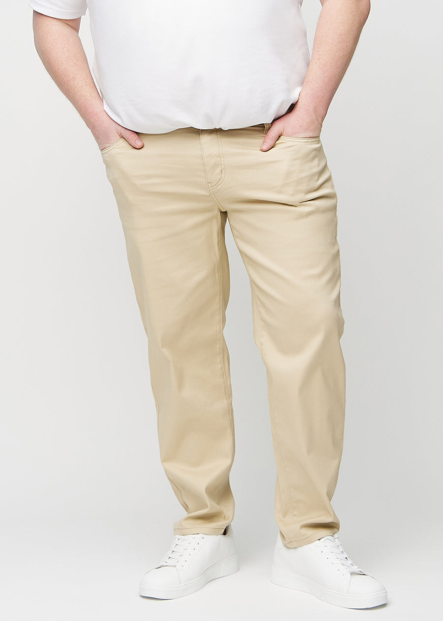Beige regular jeans, modellnamn Gazelles, som faller rakt längs benen på en plus size-modell, sedda framifrån.