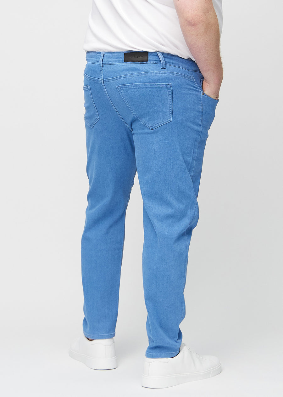 Blå regular jeans sedda bakifrån på en plus-size-modell, så att man kan se hela produkten.