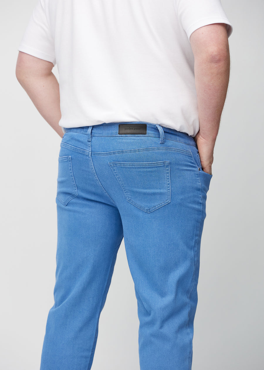 Blå regular jeans sedda bakifrån i närbild på en plus-size-modell för att visa detaljer.