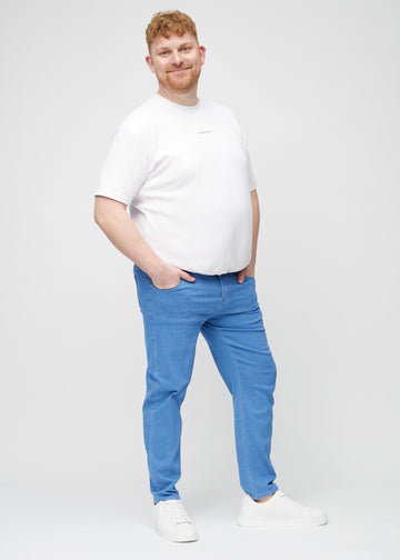 Helbild av en plus-size-modell i blå regular jeans.