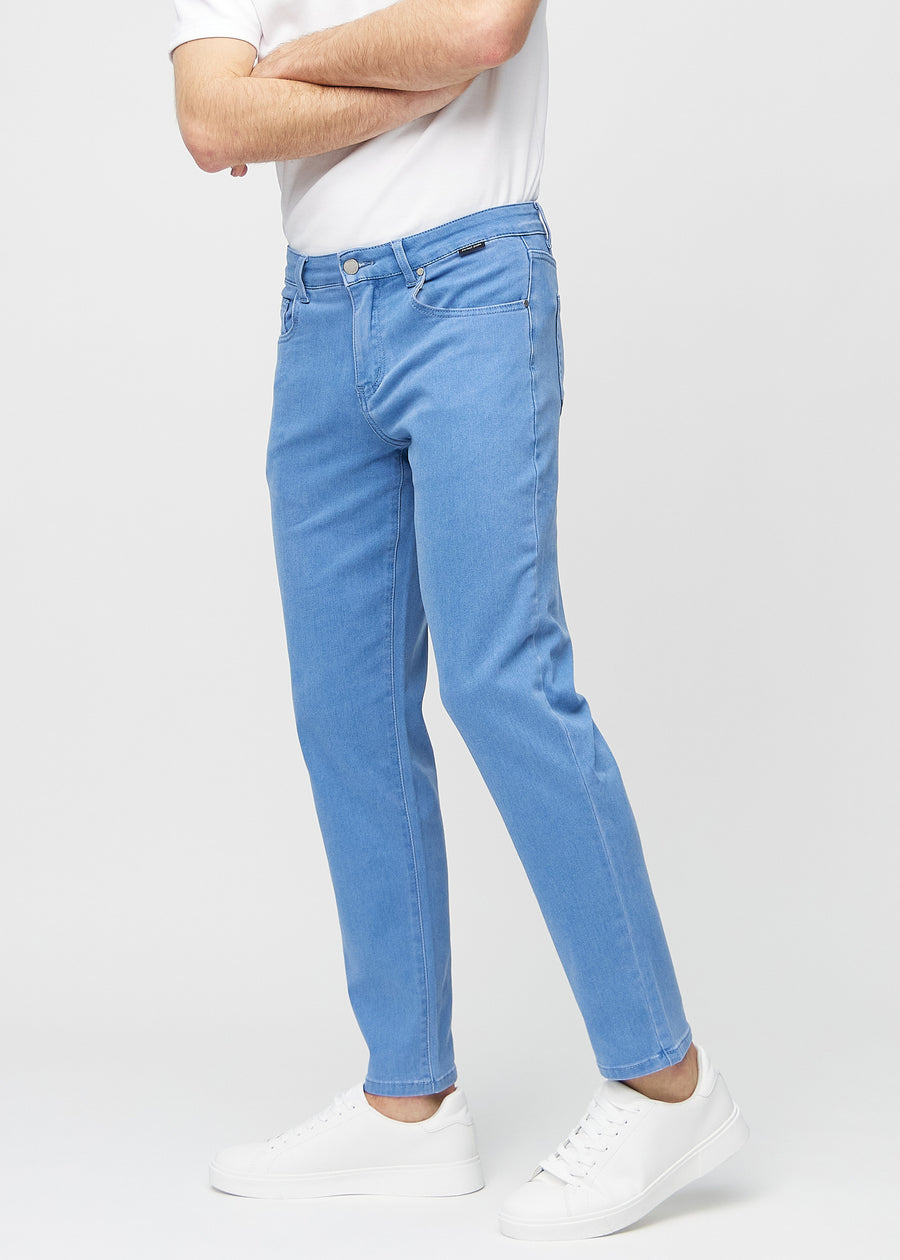 Blå regular jeans sedda från sidan på modell.