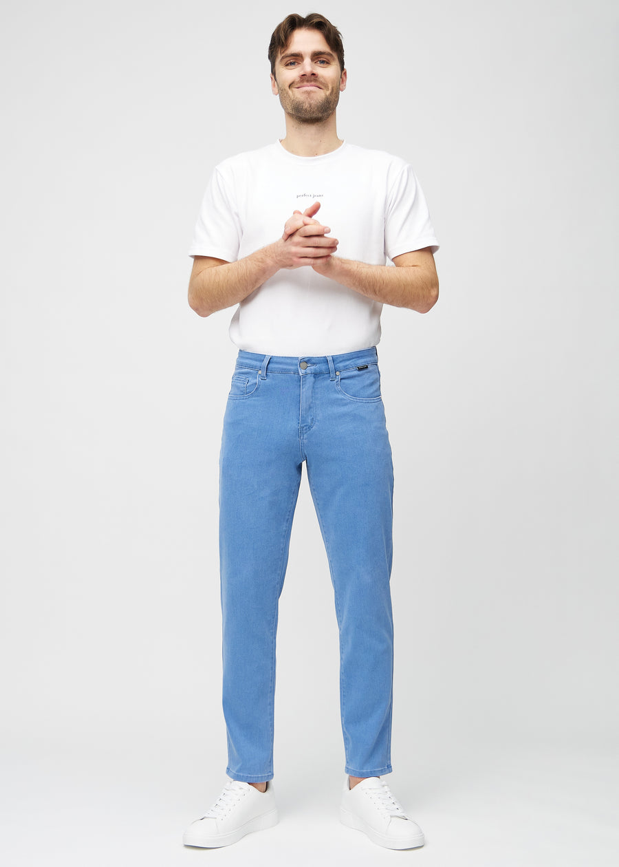 Helbild av modell i blå regular jeans.