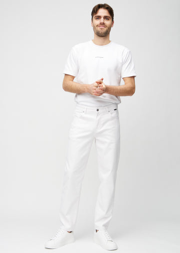 Helbild av modell i vita regular jeans.