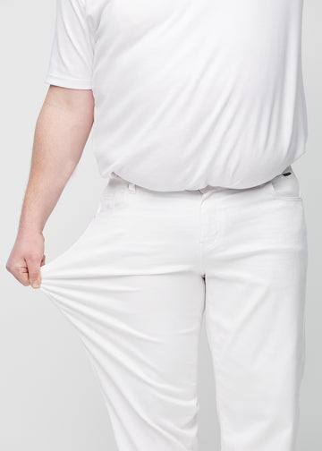 Plus-size-modellen sträcker ut jeansen vid låret för att visa stretch.