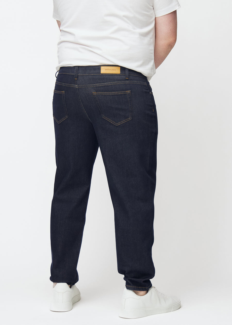 Djup mörkblå denim jeans för män i färgen Midnights sedd bakifrån på plus-size-modell.