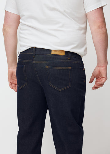 Djup mörkblå denim jeans för män i färgen Midnights sedd bakifrån på nära håll på plus-size-modell.