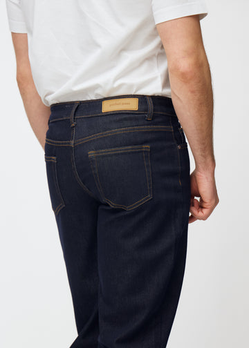 Djup mörkblå denim jeans för män i färgen Midnights sedd bakifrån på nära håll för att visa passform och detaljer.