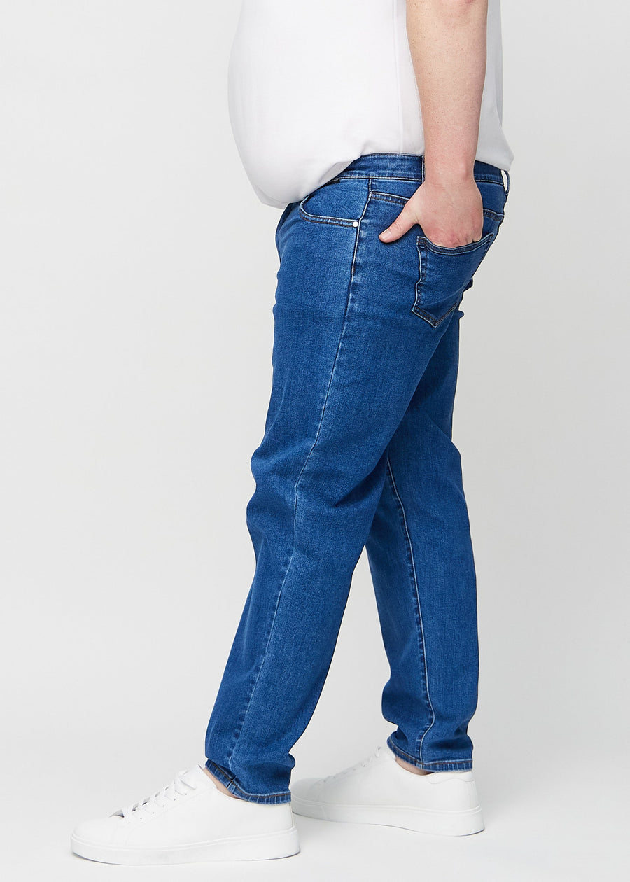 Mörkblå denim regular jeans sedd från sidan på en plus-size-modell.