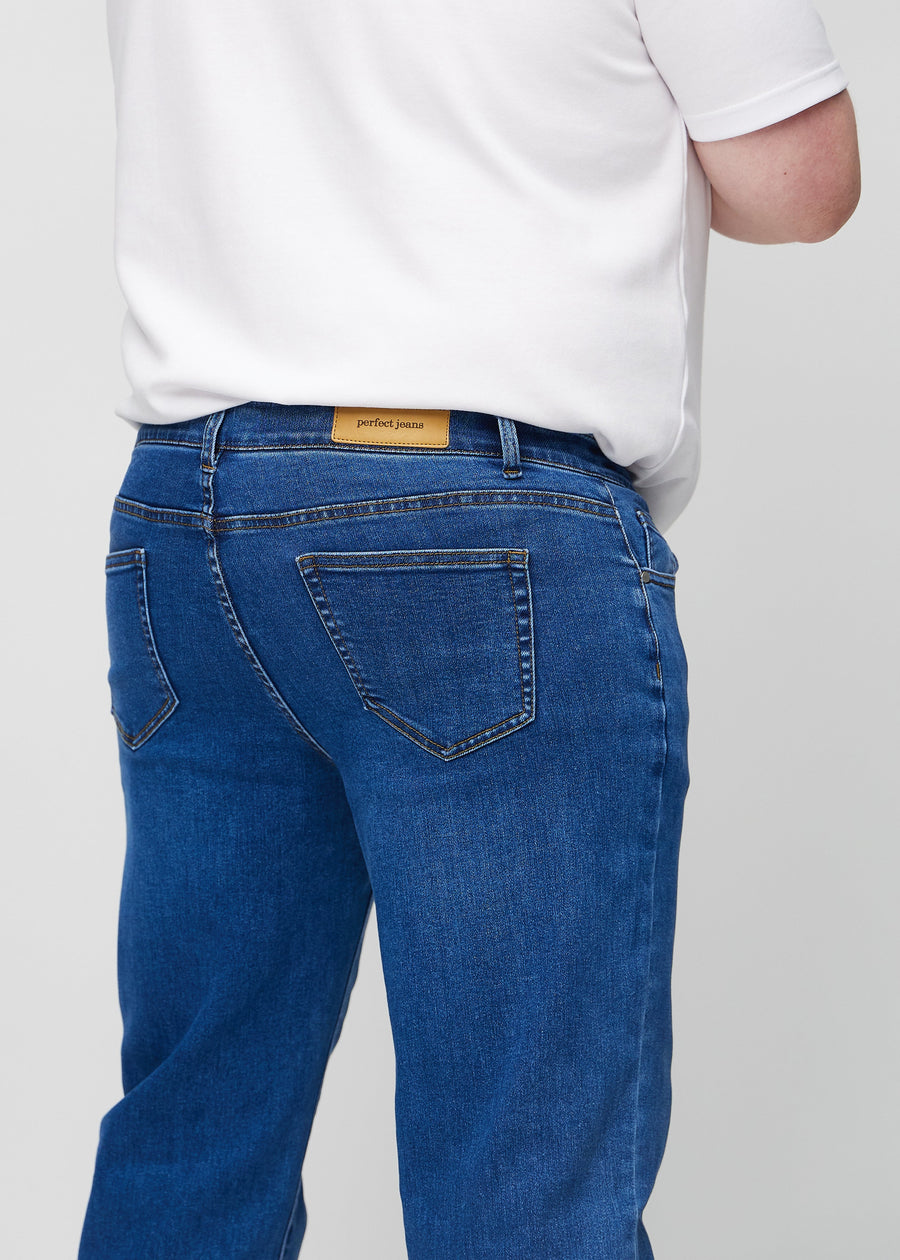 Mörkblå denim regular jeans sedd bakifrån i närbild på en plus-size-modell för att visa detaljer.