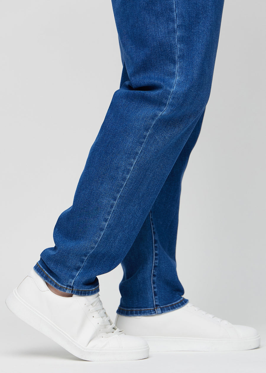 Anklarna på en plus-size-modell, så att man kan se hur löst jeansen sitter.