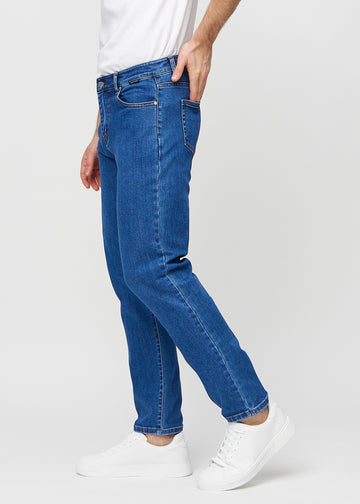 Mörkblå denim regular jeans sedd från sidan på modell.