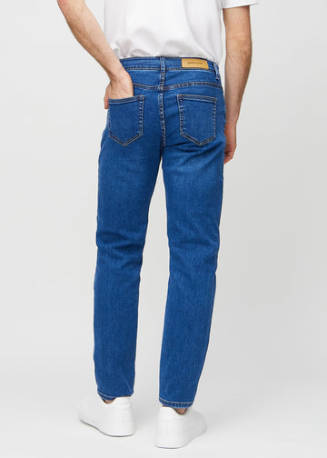 Mörkblå denim regular jeans sedd bakifrån, så att man kan se hela produkten.