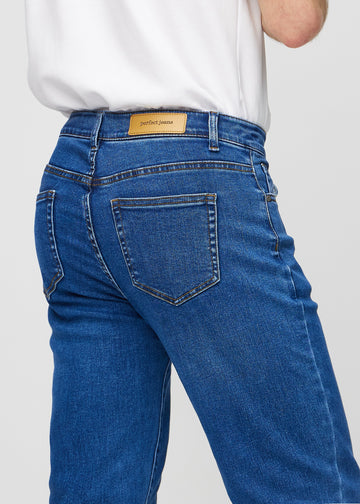 Mörkblå denim regular jeans sedd bakifrån i närbild för att visa detaljer.