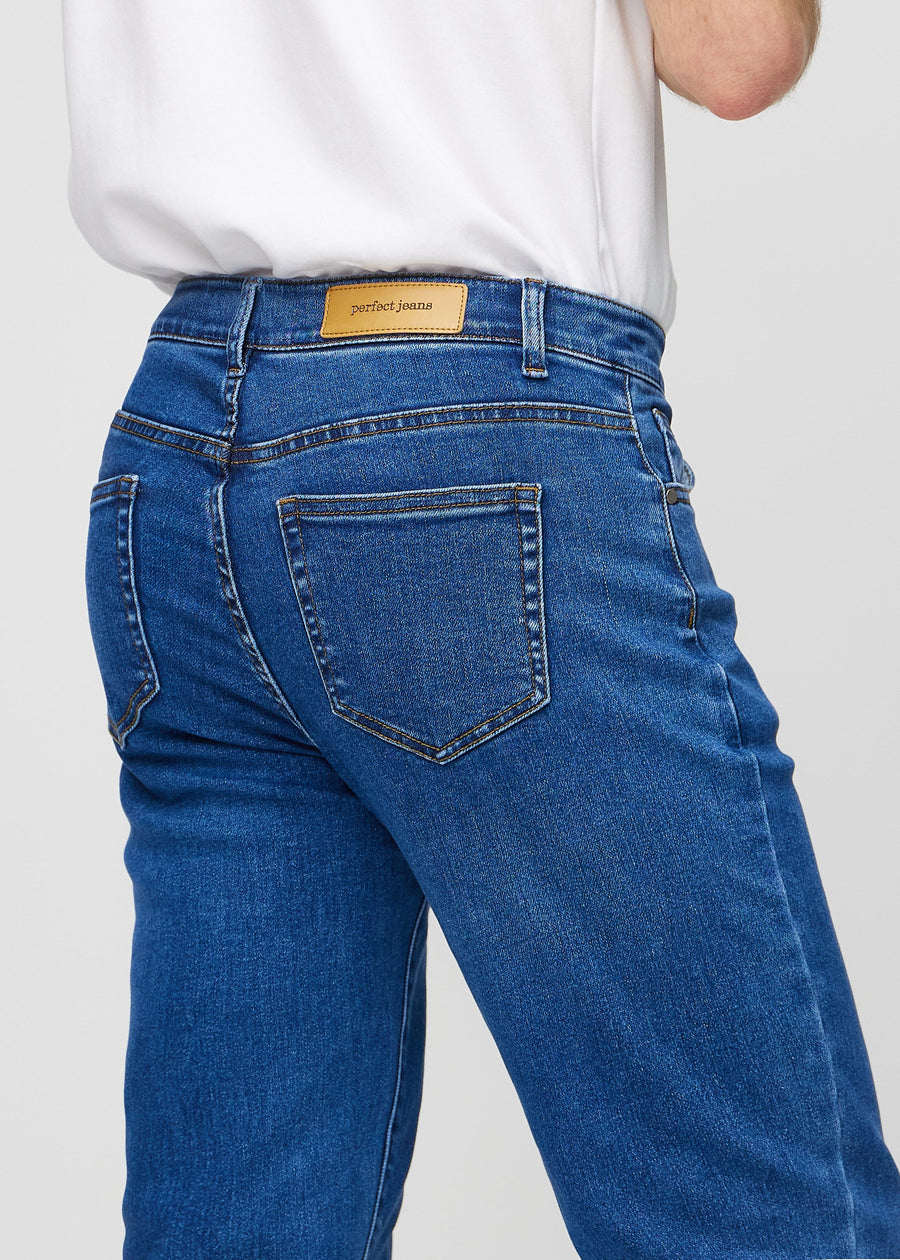Mörkblå denim regular jeans sedd bakifrån i närbild för att visa detaljer.