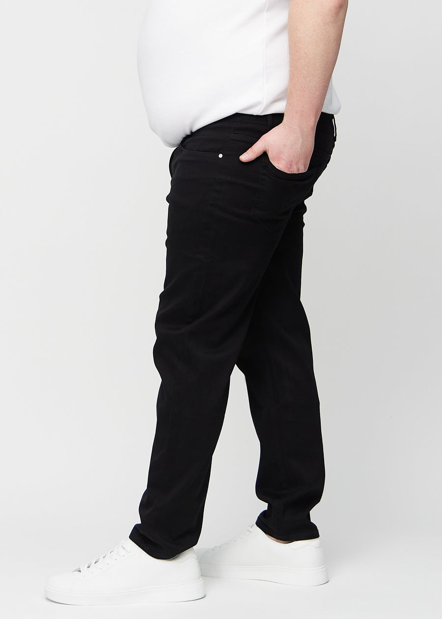Svarta regular jeans sett från sidan på en plus-size-modell.