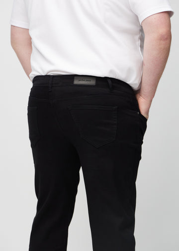 Svarta regular jeans sett bakifrån i närbild på en plus-size-modell för att visa detaljer.