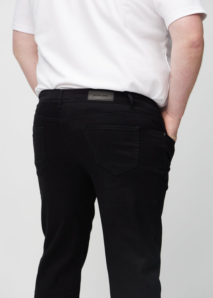 Svarta regular jeans sett bakifrån i närbild på en plus-size-modell för att visa detaljer.
