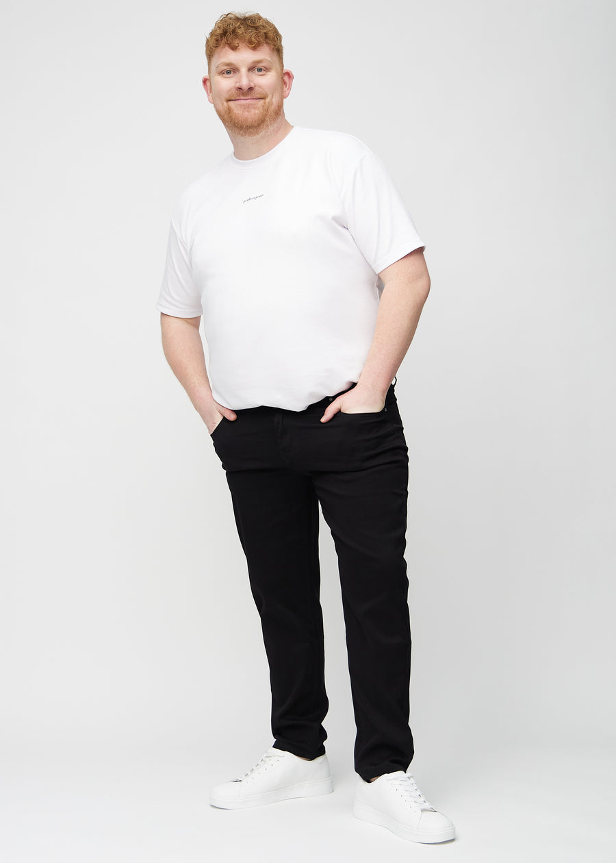 Helbild av en plus-size-modell i svarta regular jeans.