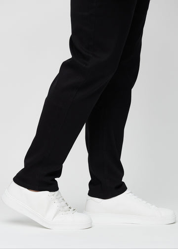 Anklarna på en plus-size-modell, så att man kan se hur löst jeansen sitter.
