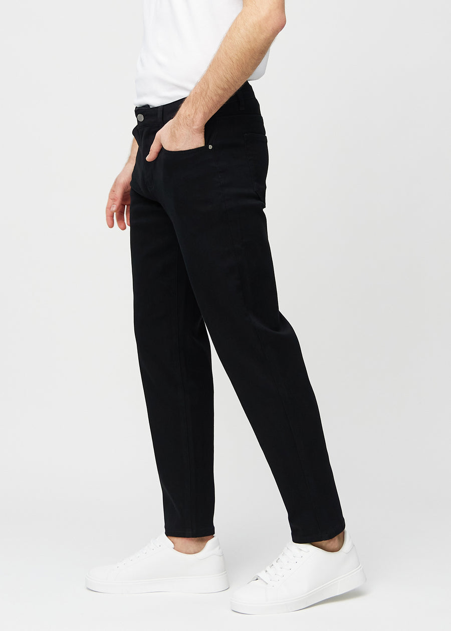 Svarta regular jeans sett från sidan på modell.
