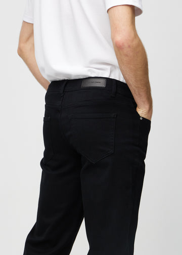 Svarta regular jeans sett bakifrån i närbild för att visa detaljer.