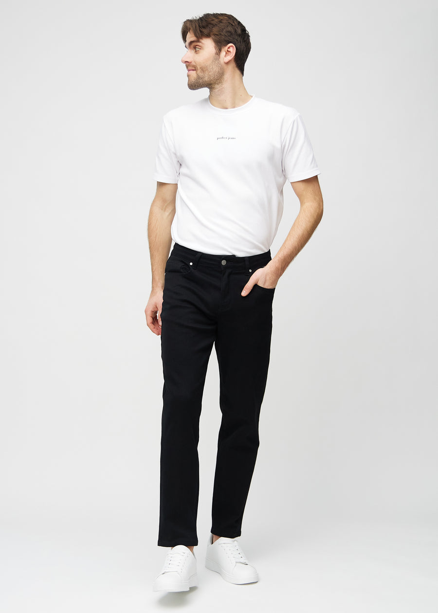 Helbild av modell i svarta regular jeans.