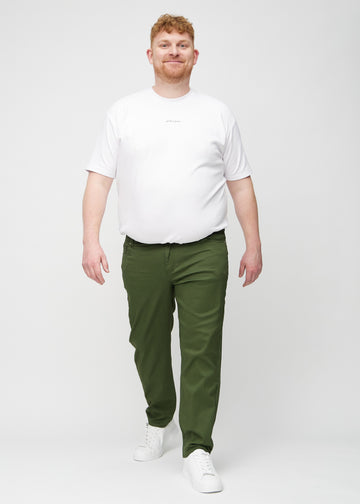 Helbild av en plus-size-modell i mörkgröna regular jeans.