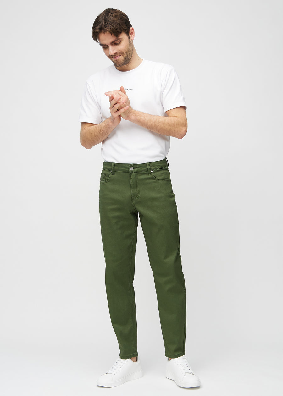 Helbild av modell i mörkgröna regular jeans.