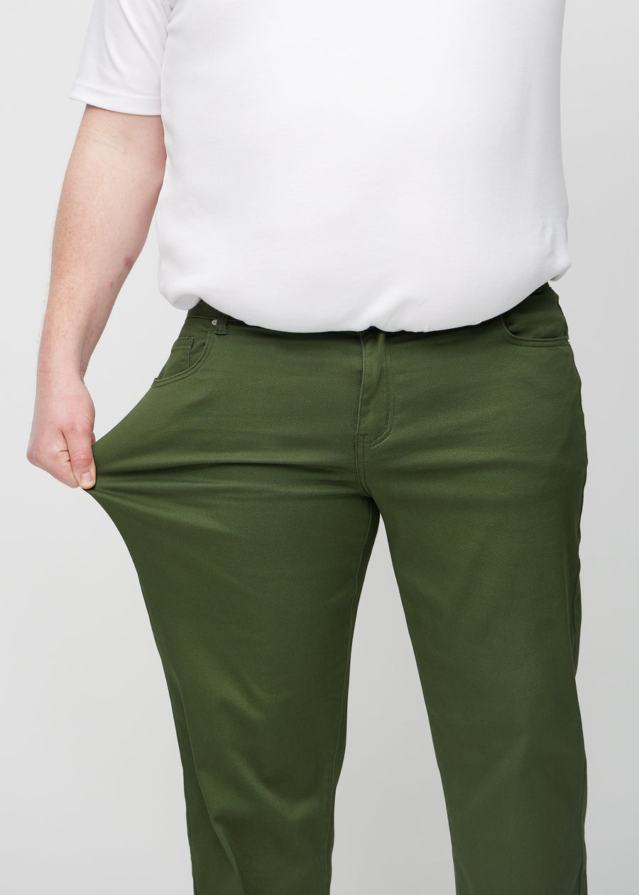 Plus-size-modellen sträcker ut jeansen vid låret för att visa stretchen.