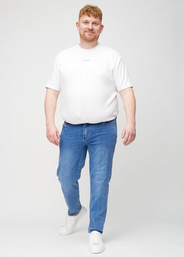 Helbild av en plus size-modell i denimjeans med regular fit.