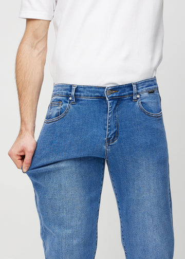 Modellen drar ut jeansens tyg vid låret för att visa stretchen.