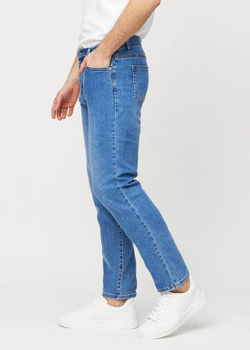 Denimjeans i regular fit sedda från sidan på en modell.