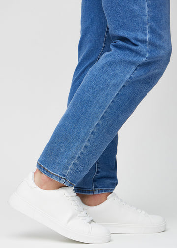 Närbild av modellens anklar som visar hur löst jeansen sitter.