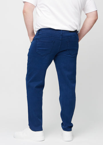 Mörkblå regular jeans sedd bakifrån på en plus-size-modell, så att man kan se hela produkten.