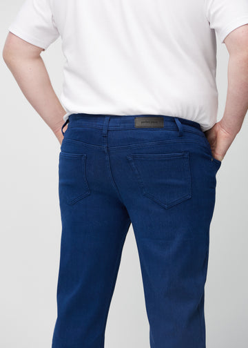 Mörkblå regular jeans sedd bakifrån på nära håll på en plus-size-modell för att visa detaljer.