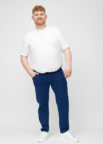 Helbild av en plus-size-modell i mörkblå regular jeans.