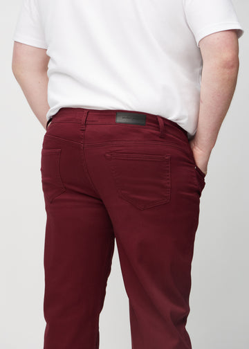 Mörkröda regular jeans sett bakifrån på nära håll på en plus-size-modell för att visa detaljer.