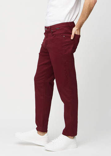 Mörkröda regular jeans sett från sidan på modell.