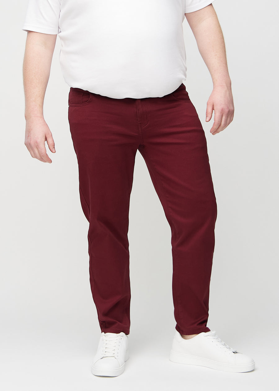 Mörkröda regular jeans, modellnamn Santas, som går rakt ner längs benet på en plus-size-modell, sett framifrån.