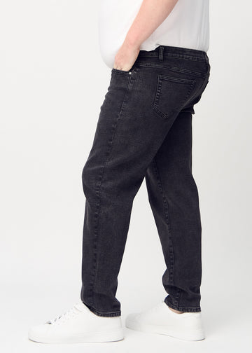 Mörkgrå denim regular jeans sedd från sidan på en plus-size-modell.