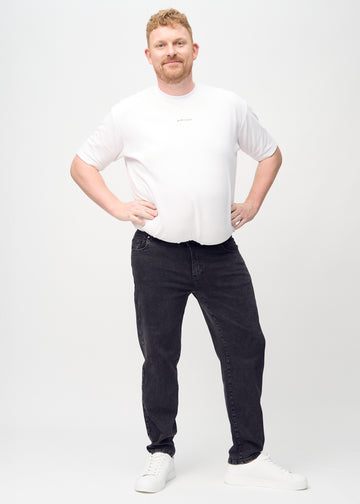Helbild av en plus-size-modell i mörkgrå denim regular jeans.