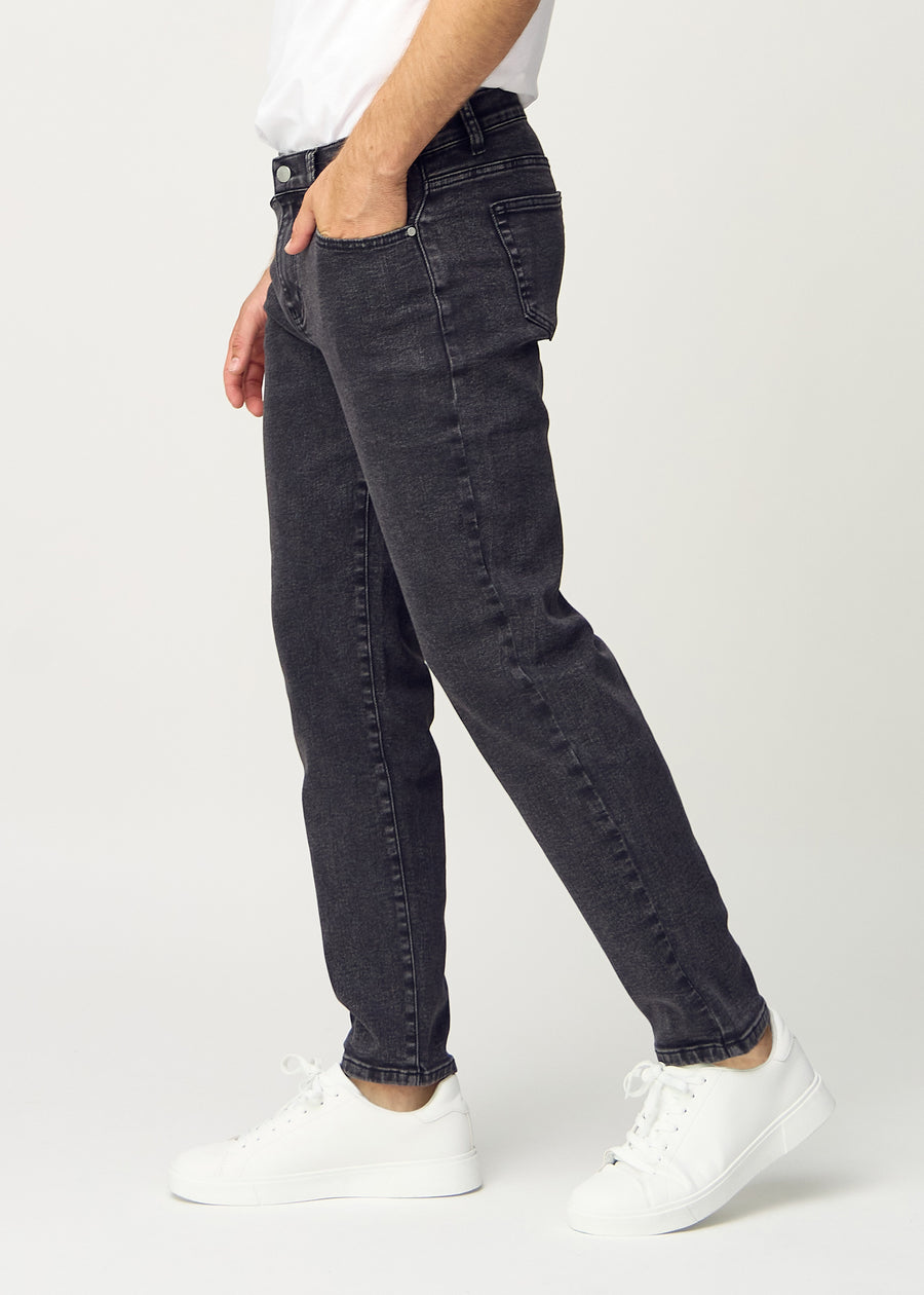 Mörkgrå denim regular jeans sedd från sidan på modell.