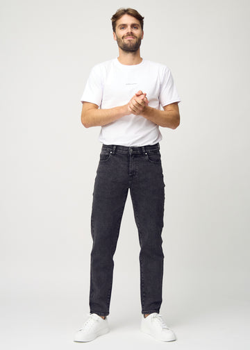 Helbild av modell i mörkgrå denim regular jeans.