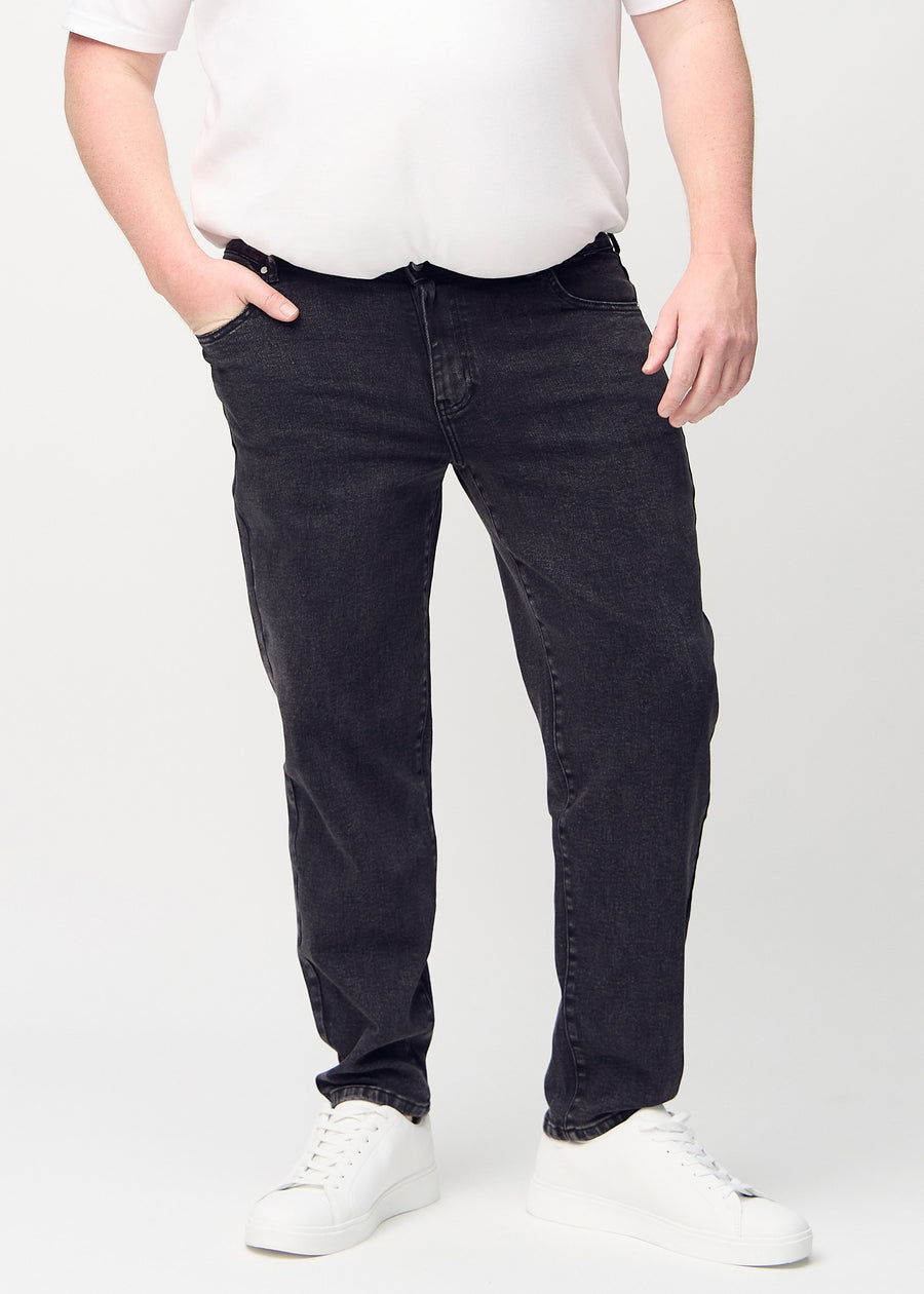 Mörkgrå denim regular jeans, modellnamn Shadows, som går rakt ner längs benet på en plus-size-modell, sett framifrån.