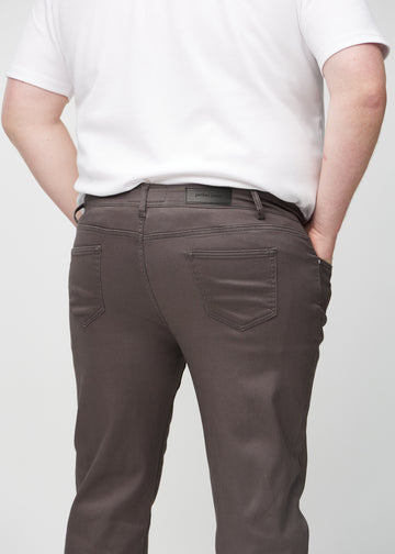 Gråbruna regular jeans sedda bakifrån i närbild på en plus size-modell för att visa detaljer.